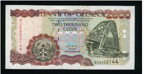 2000 Cedis.

Reduced Size Issue.

Suspension bridge at right, arms at lower left center on face; fisherman loading nets into boat at left on back.

Pick #33 Banknote