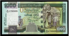 1,000 Rupees.

Chinze at lower left, two-heaaded bird at bottom center, elephant with trainer at right on face; peacocks on palace lawn, lotus flowers above and Octagon of Temple of the Tooth in Kandy on back.

Pick #NEW Banknote