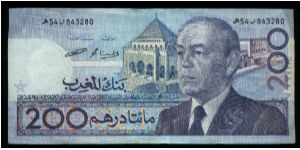 200 Dirhams.

Older bust of King Hassan II at right, mausoleum of King Muhammad V at center on face; sailboat, shell and coral on back. Banknote