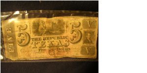 The Republic of Texas; Five dollar note.  Mirabou B. Lamar signature.  Cancelled at bottom with an X cut through the paper.

This note was found in an old agricultural book, stuck away in a chest. Banknote