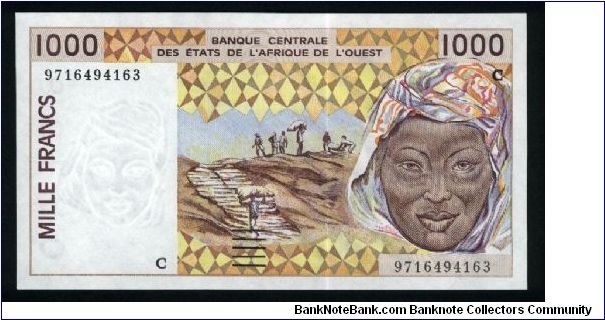 1000 Francs.

Workmen hauling peanuts to storage and woman's head on face; twin statues and mask on left, two women with baskets, elevated riverside storage bins in background on back.

Pick #311C-h Banknote